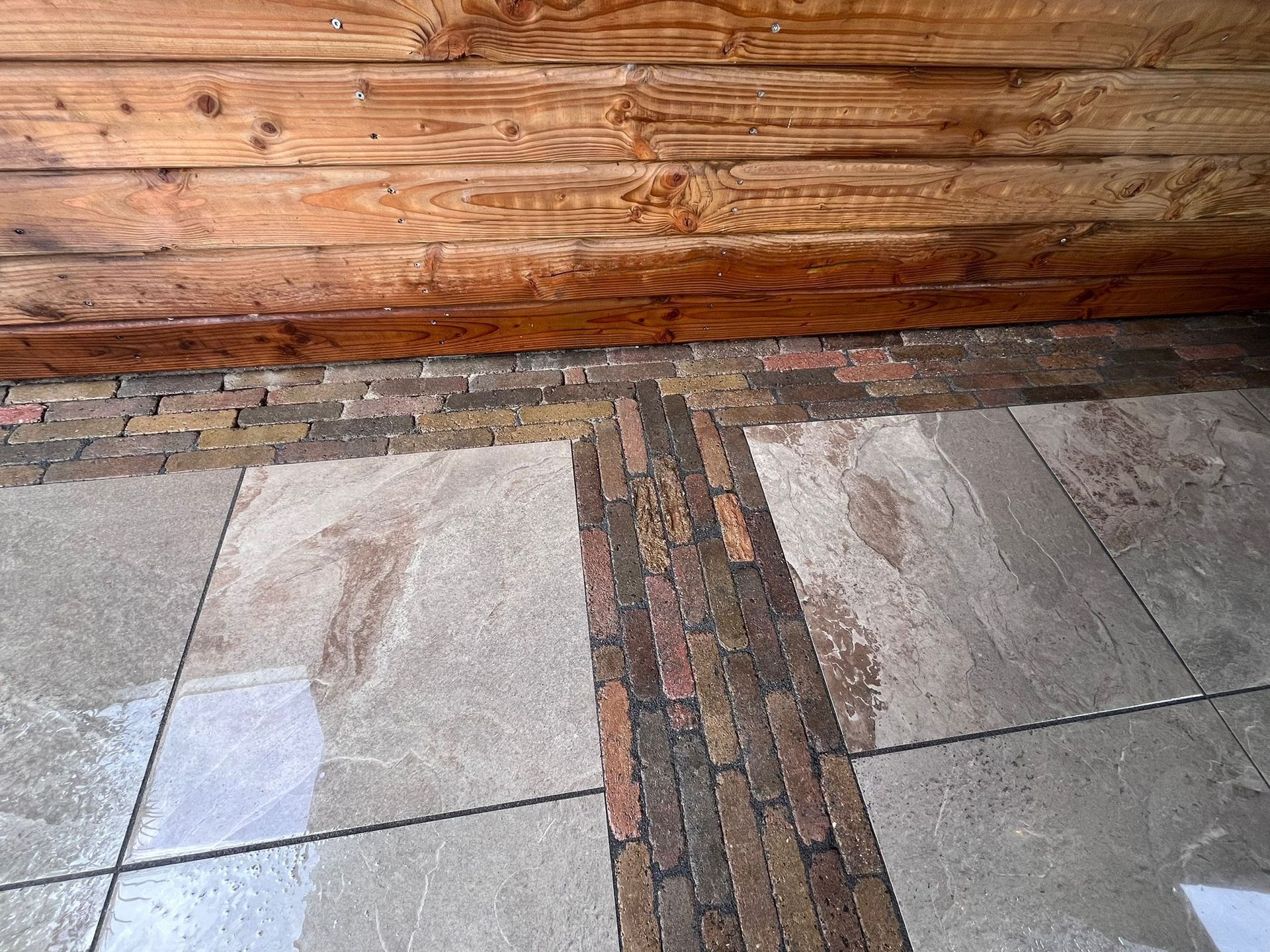Houten wand boven tegelvloer met waterschade en donkere vlekken.