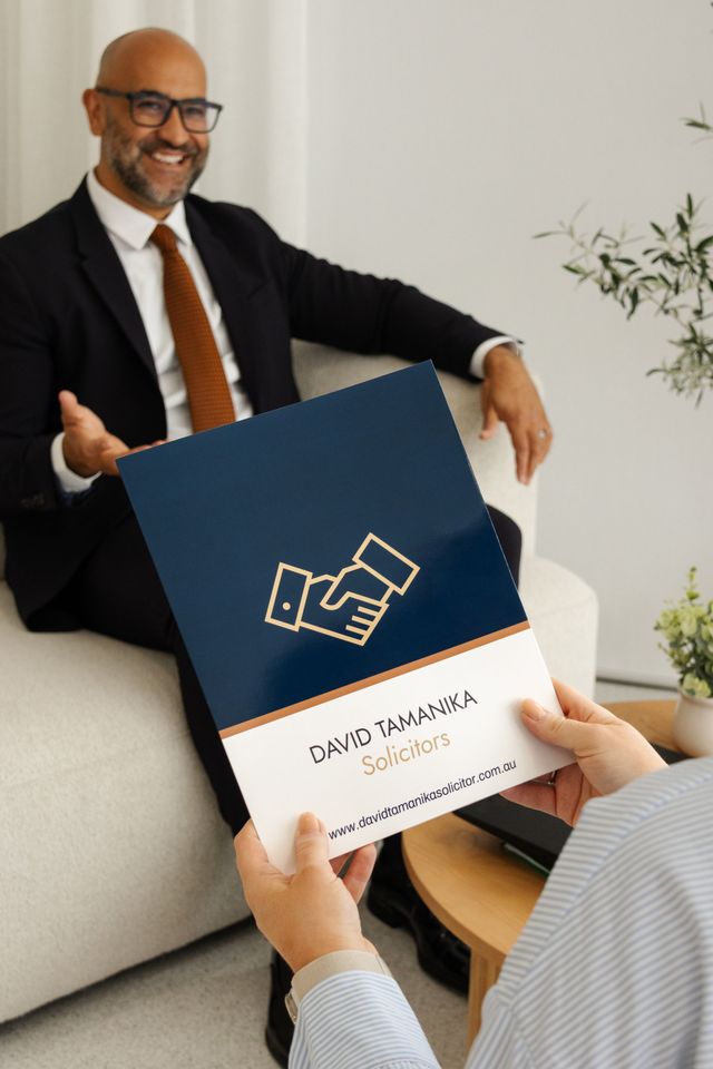David is handing over a brochure — David Tamanika Solicitors in Ballarat Central, VIC