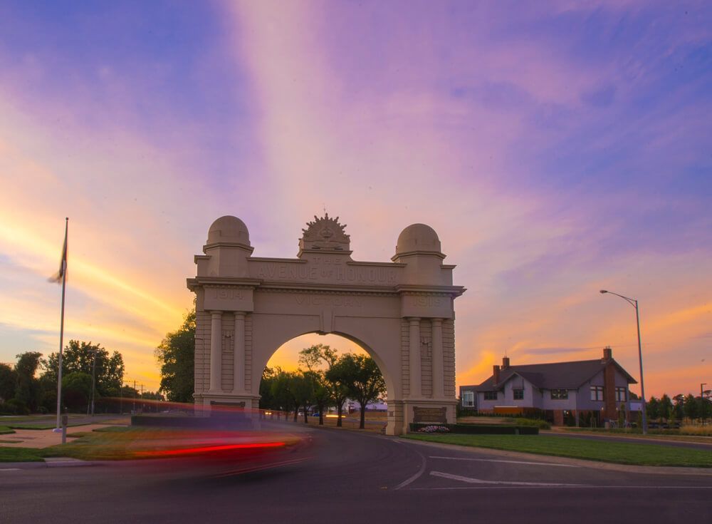 A Car Is Driving Past An Archway At Sunset — David Tamanika Solicitors in Ballarat, VIC