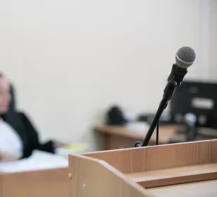 A Microphone Is On Top Of A Wooden Podium — David Tamanika Solicitors in Ballarat Central, VIC