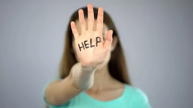 A Woman Is Covering Her Face With Her Hand With The Word Help Written On It — David Tamanika Solicitors in Bacchus Marsh, VIC