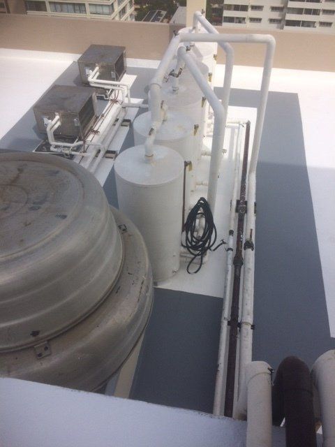 A rooftop with a lot of pipes and containers