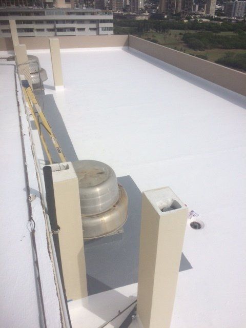 A white roof with a few chimneys on it