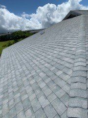 A close up of a roof with a blue sky and clouds in the background.