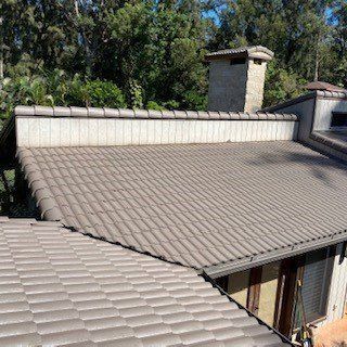 A house with a tiled roof and a chimney on the roof.
