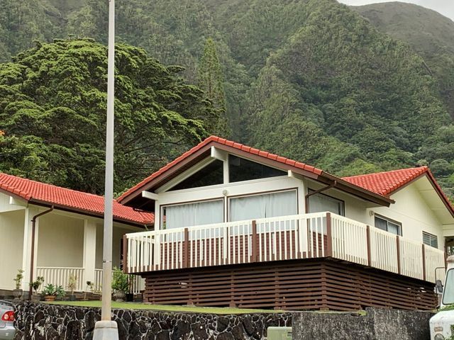 A white house with a red roof and a balcony