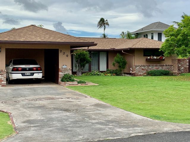 A car is parked in a driveway in front of a house.