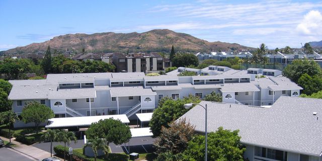 A large white building with a mountain in the background