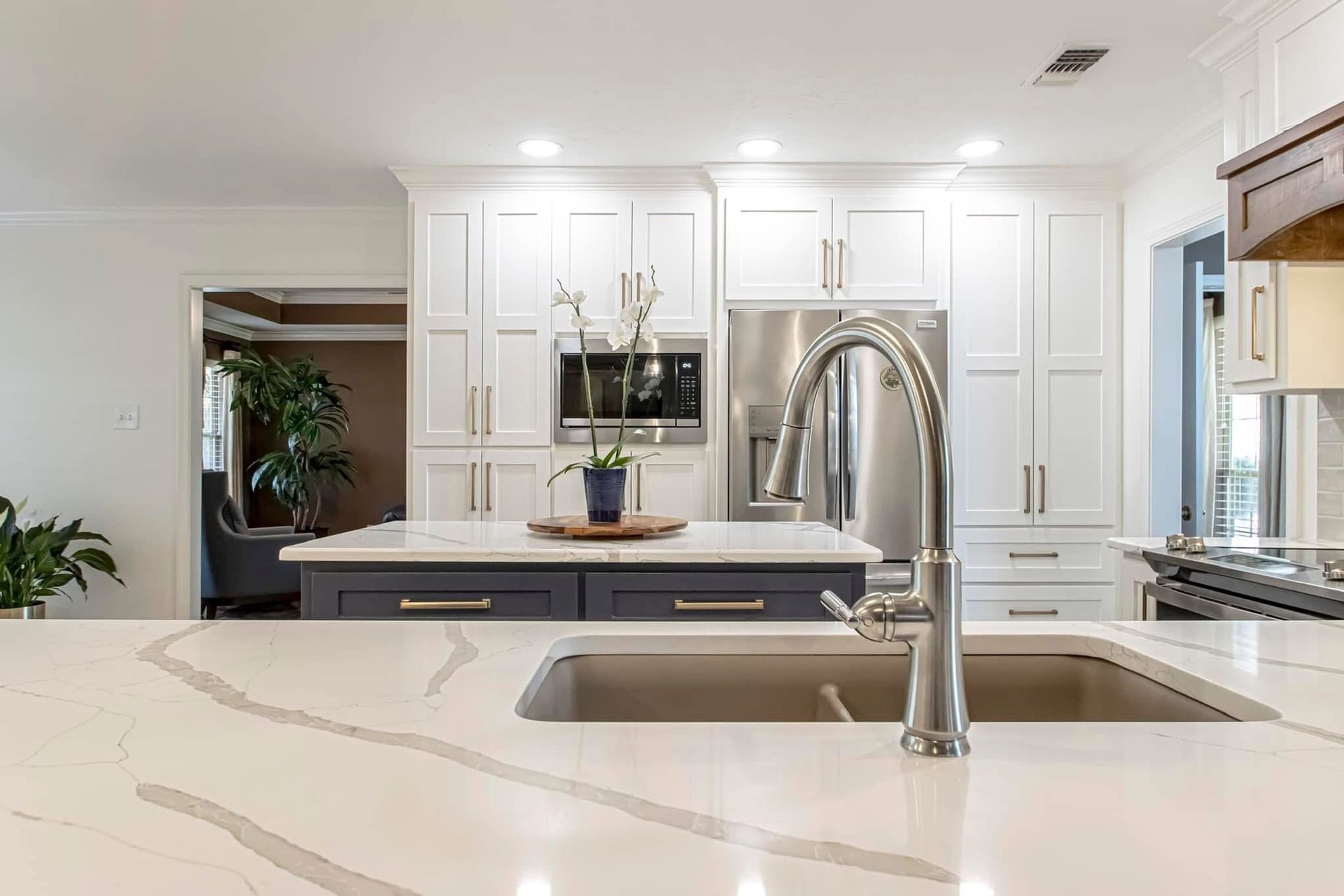 Bright white modern kitchen with marble island, stainless sink, and built-in appliances