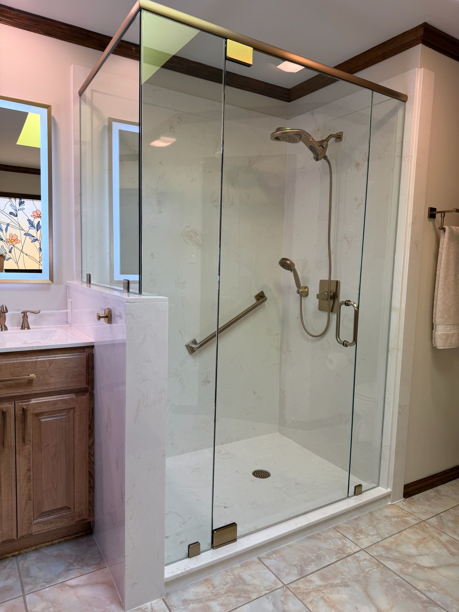 Walk-in glass shower with white tile and chrome fixtures in a bathroom