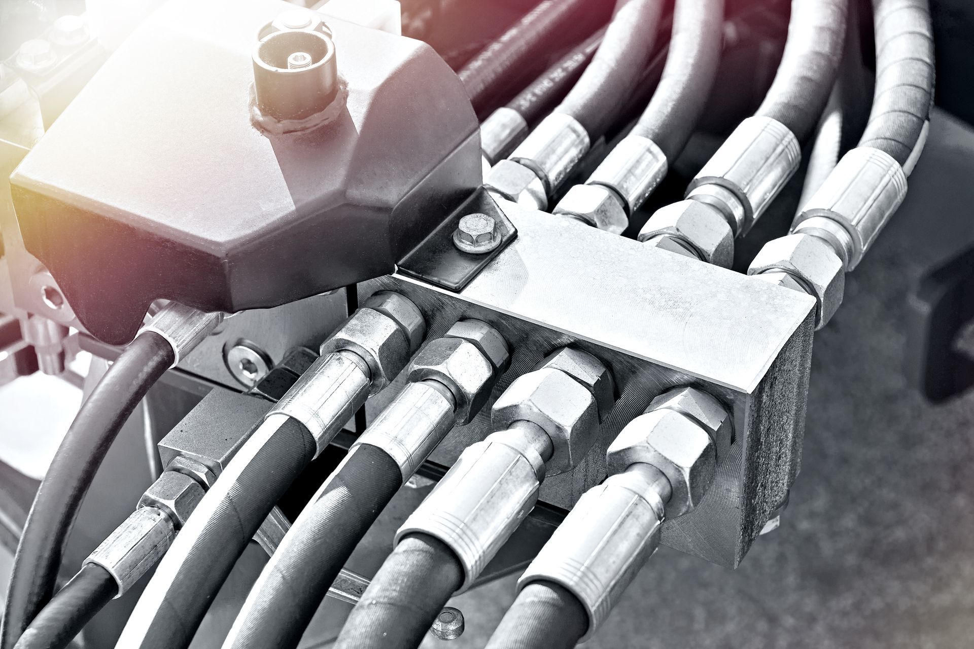 A close-up of hydraulic fittings to heavy machinery.