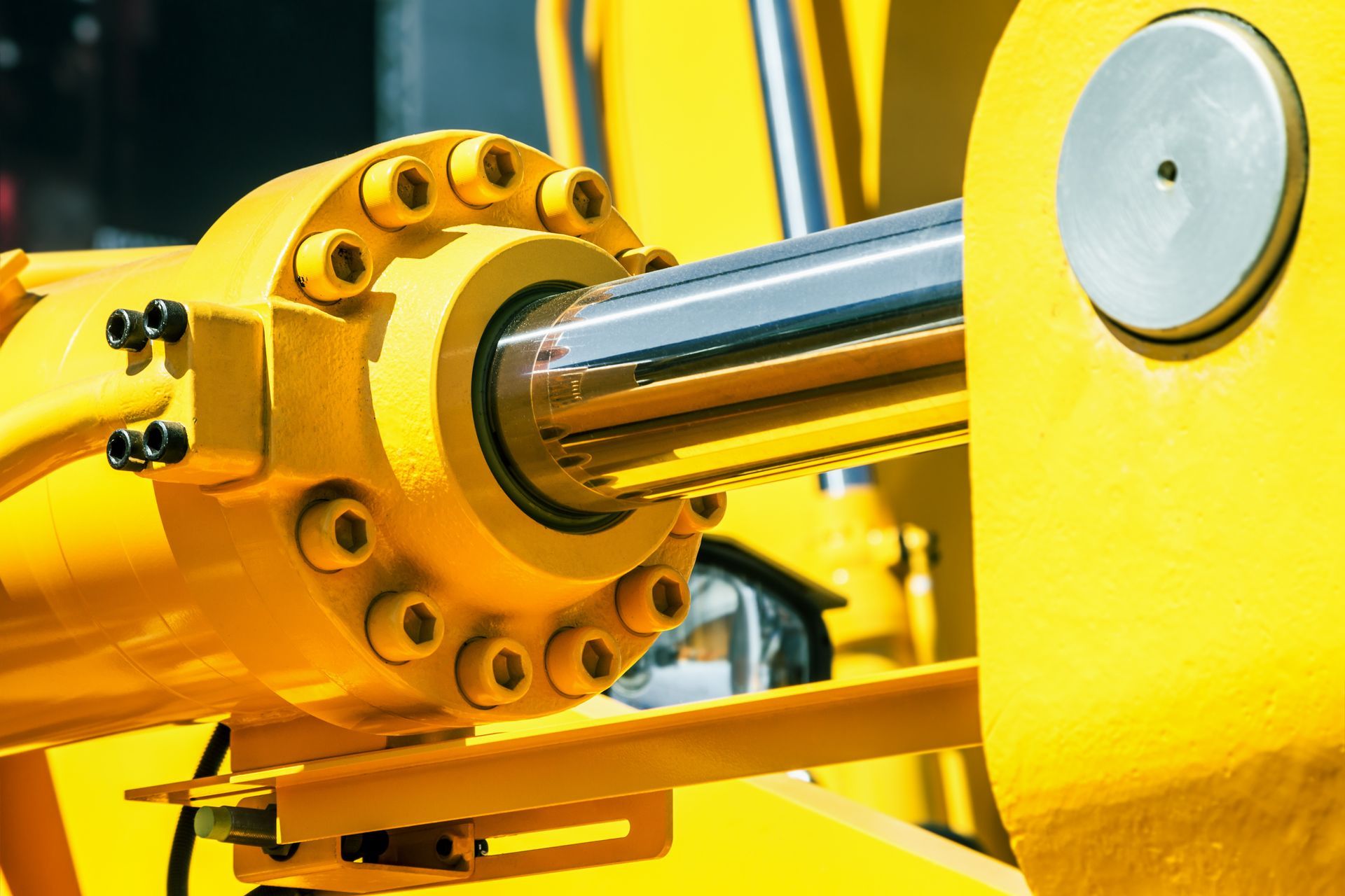 A close-up of a hydraulic cylinder of a tractor or an excavator A close-up of a hydraulic cylinder of a tractor or an excavator