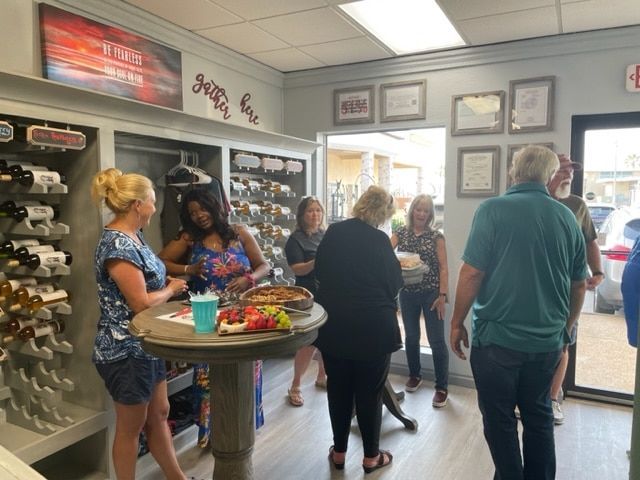 People chatting in a small shop near a round display table and front door