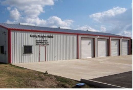 A fire station with a red trim has a lot of garage doors