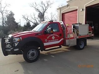A red fire truck is parked in front of a fire station.