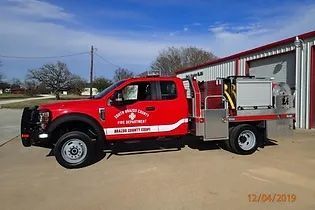 A red fire truck is parked in front of a building.