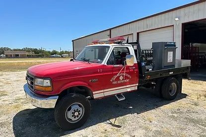 A red and white truck is parked in front of a building.