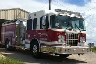 A red and white fire truck is parked in front of a building.