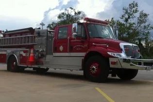A red and silver fire truck is parked in a parking lot.