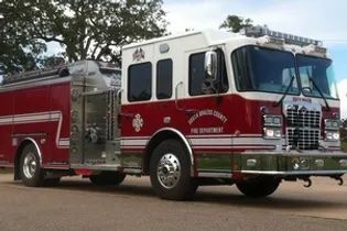 A red and white fire truck is parked on the side of the road.