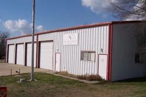 A fire station building with a red trim has a lot of garage doors