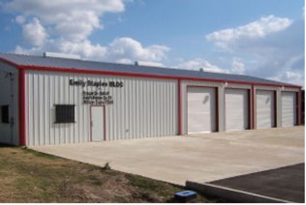 A fire station building with a red trim has a lot of garage doors