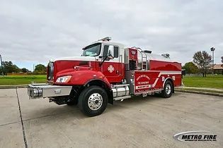 A red and white fire truck is parked on the side of the road.