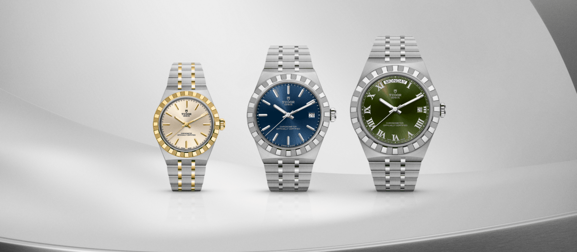 Drie horloges op een grijze achtergrond: goud en zilver, een horloge met blauwe wijzerplaat en met een groene wijzerplaat.