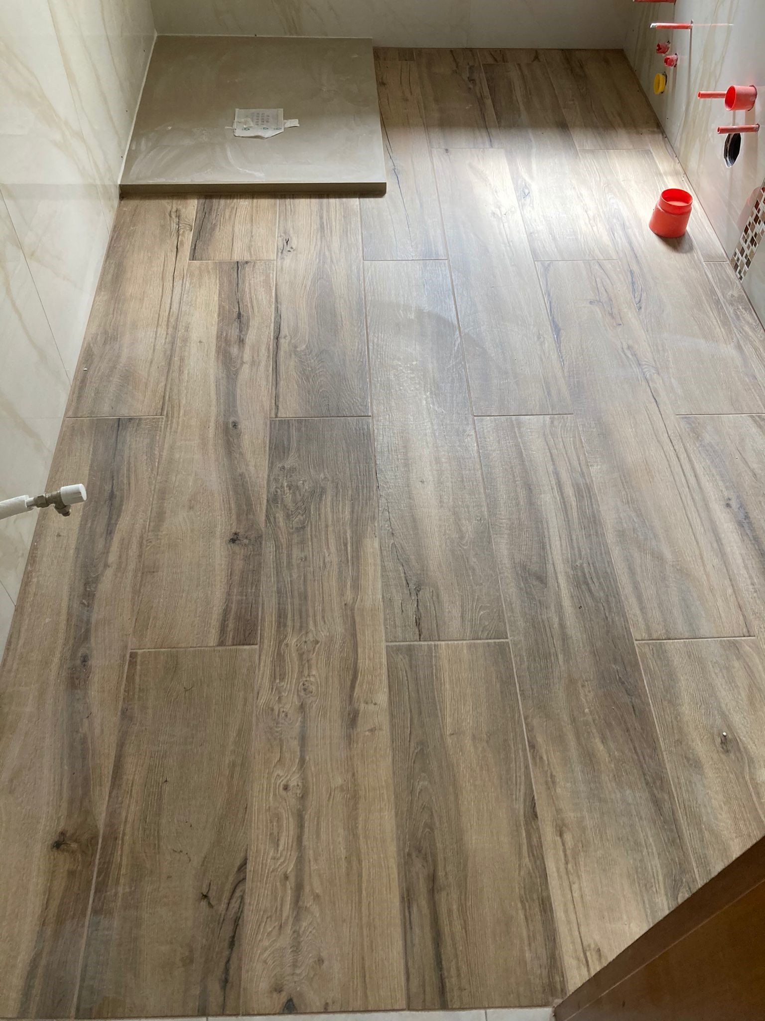 Un bagno con pavimento in legno e box doccia.