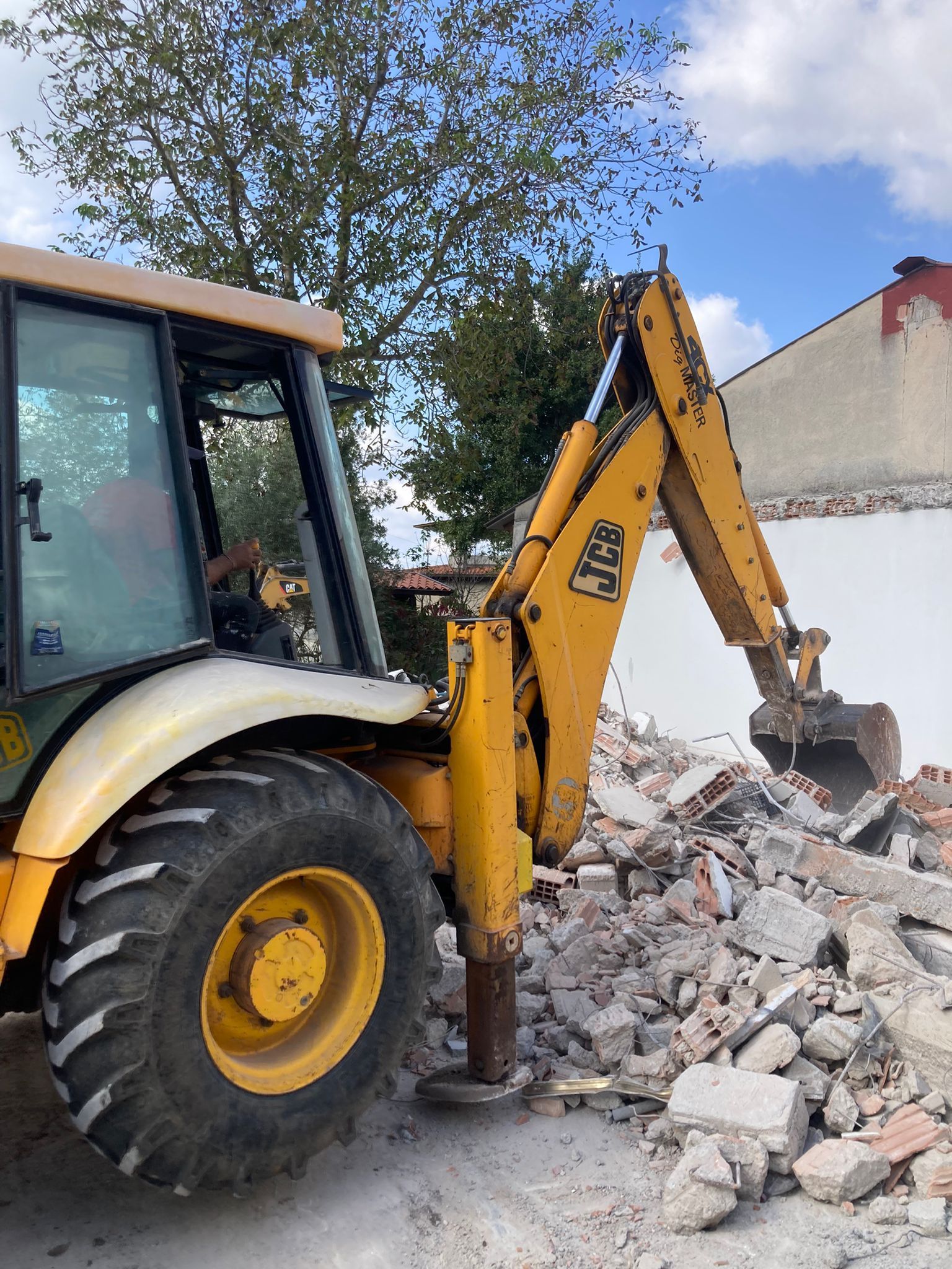 Un trattore giallo e bianco sta attraversando un mucchio di rocce.