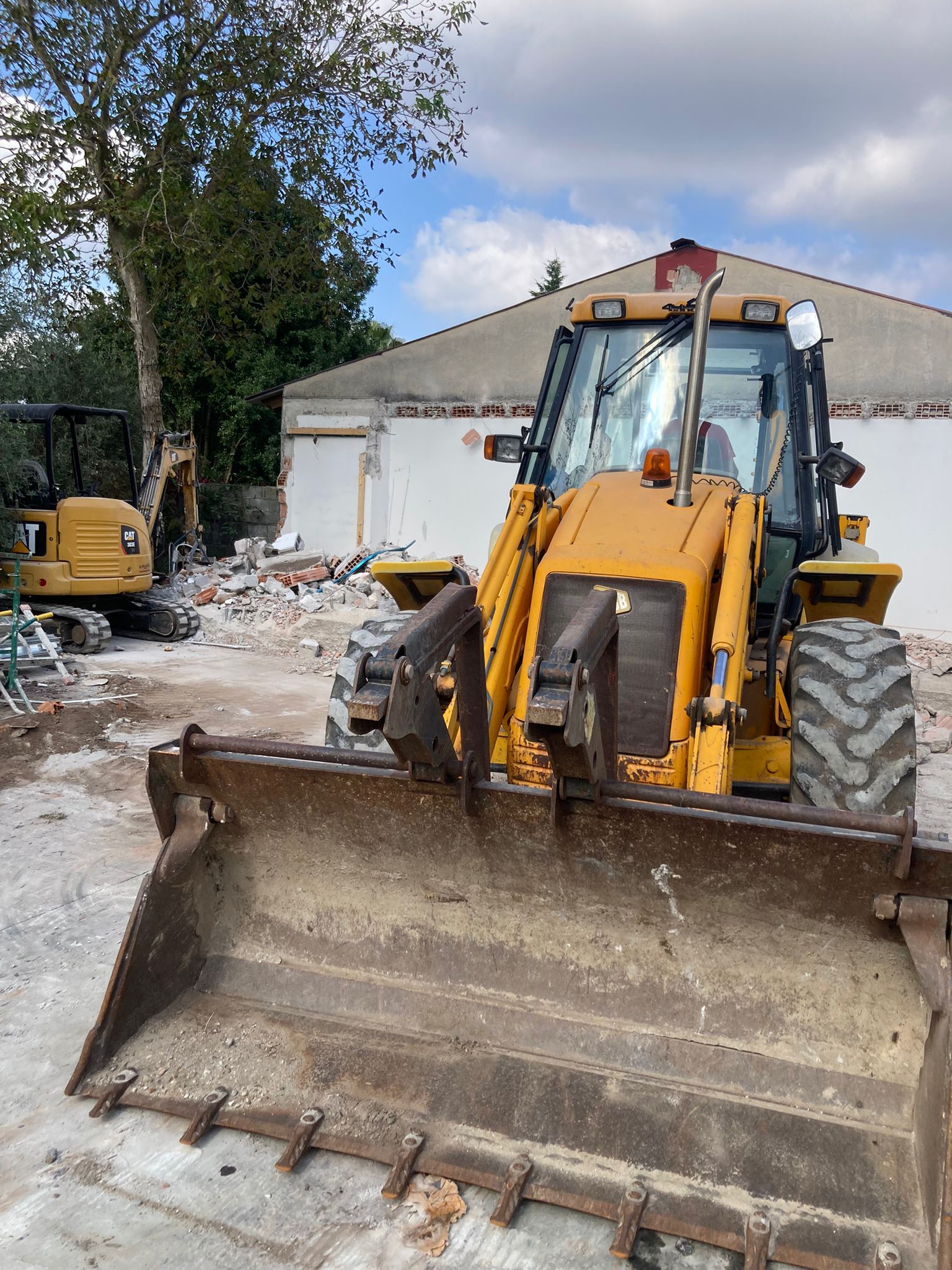 Un bulldozer giallo è parcheggiato davanti a un edificio in un cantiere edile.