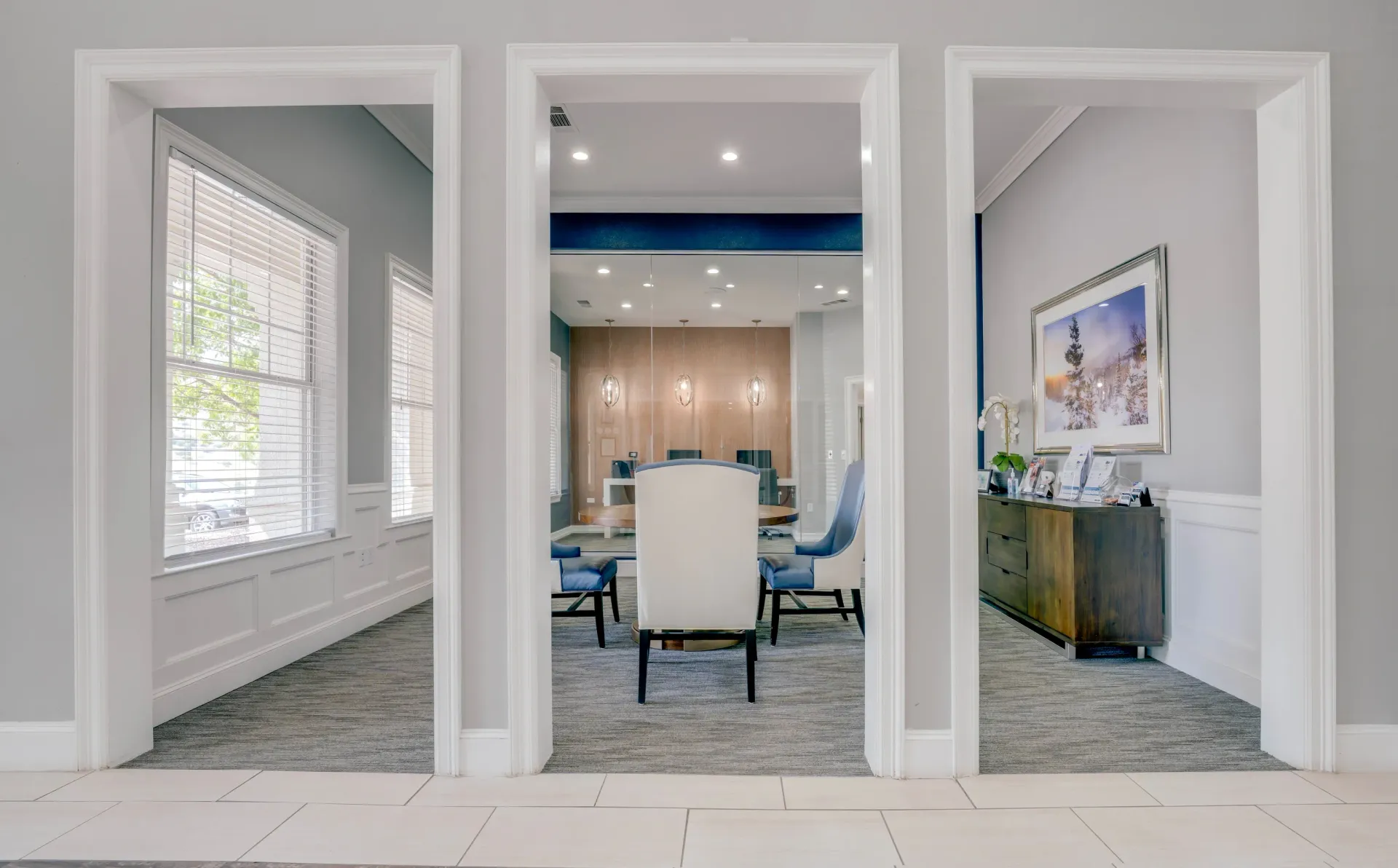 View through doorways into a leasing office with chairs and desks.