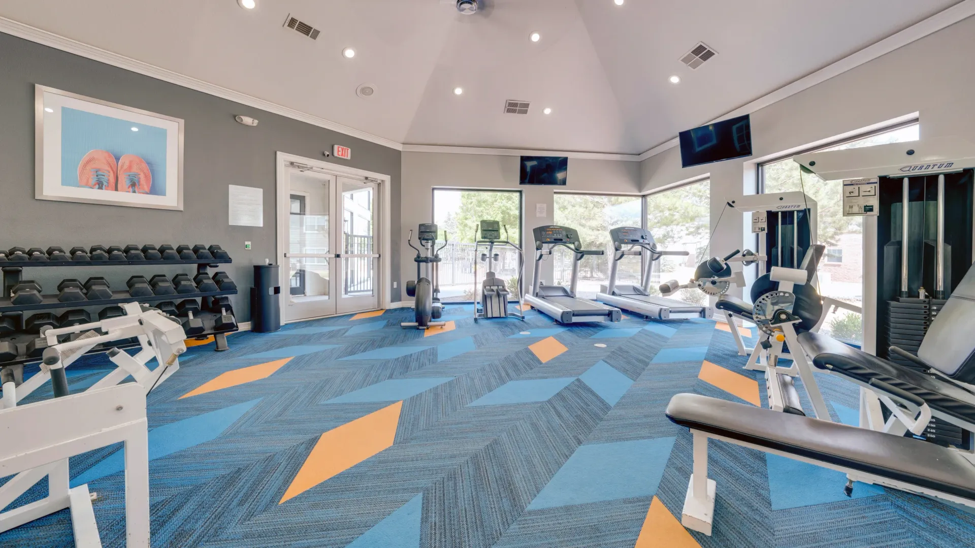 Fitness center with treadmills, ellipticals, weight machines, and free weights.