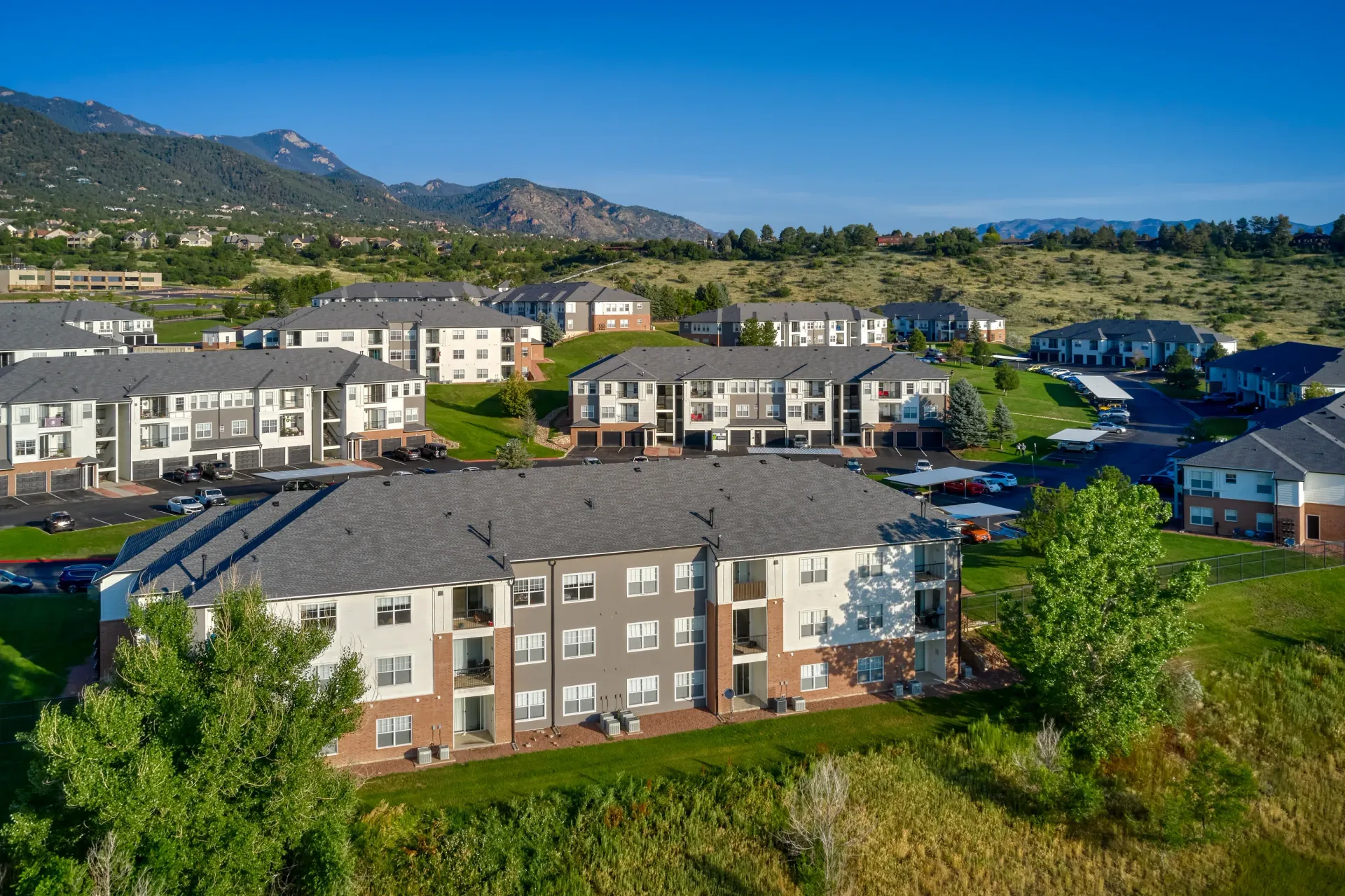 Aerial view of apartment buildings with mountains in the background.