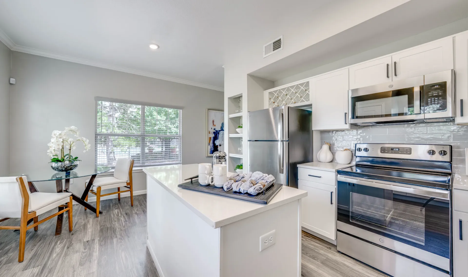 Modern kitchen with stainless steel appliances, island, and dining area.