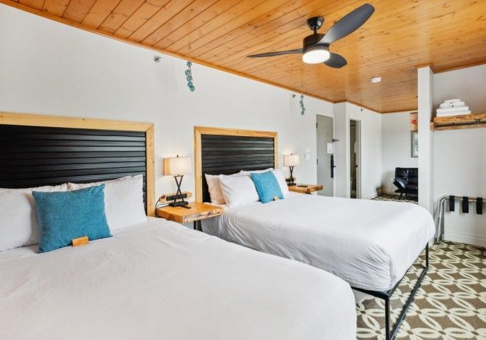 Two beds with two blue pillows