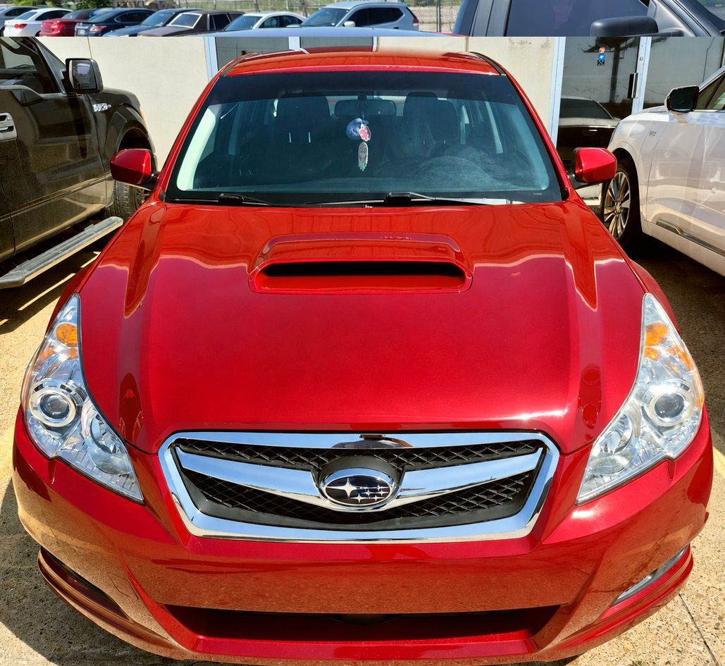 Red sedan with hood scoop parked in a lot, front view, bright red paint