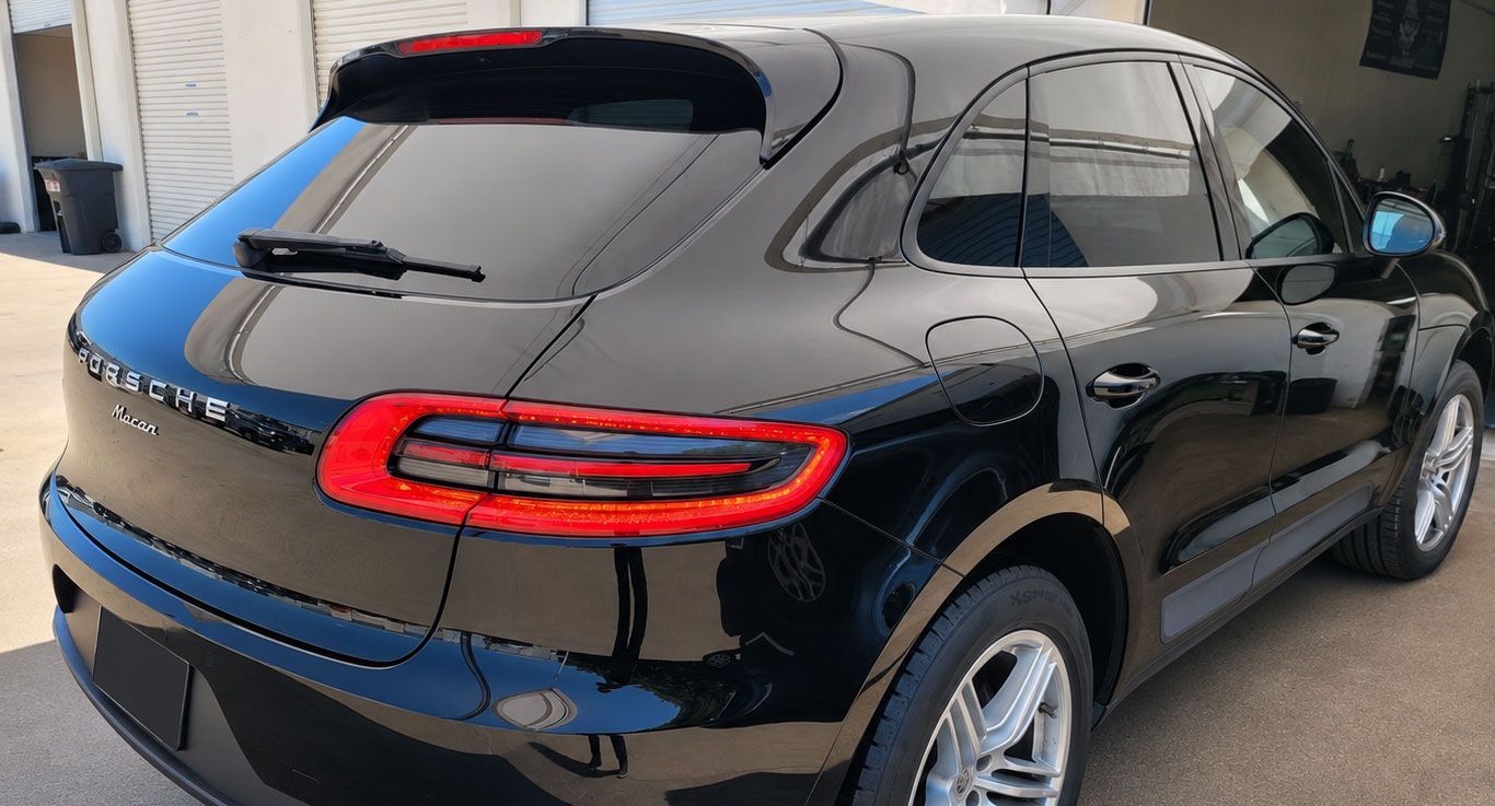 Black crossover SUV parked outdoors, rear three-quarter view, with red taillights and tinted windows