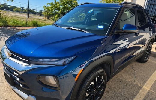 Blue SUV parked outdoors on a sunny street, front-left view with black wheels and chrome trim