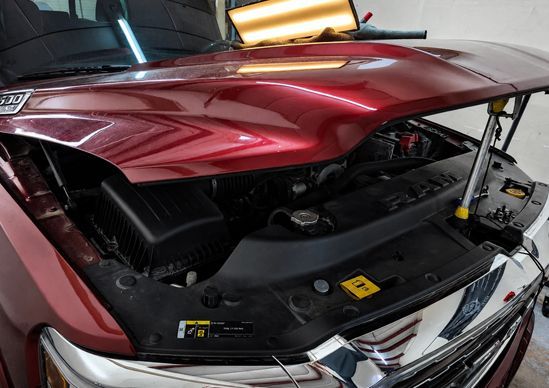 Damaged silver Toyota sedan with a crumpled hood and front-end collision damage