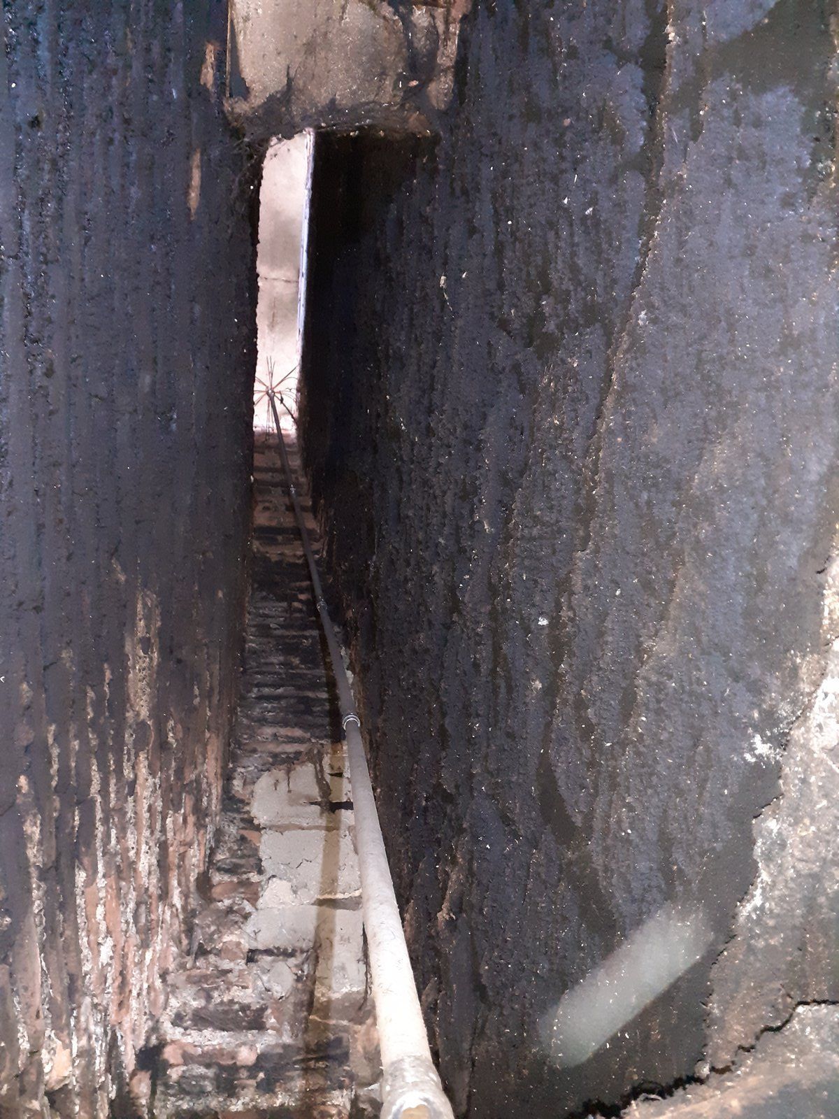 Étroite crevasse rocheuse avec un petit passage et de l'eau en dessous