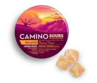 Round Camino Sours candy tin in sunset colors with three sugar-coated gummies