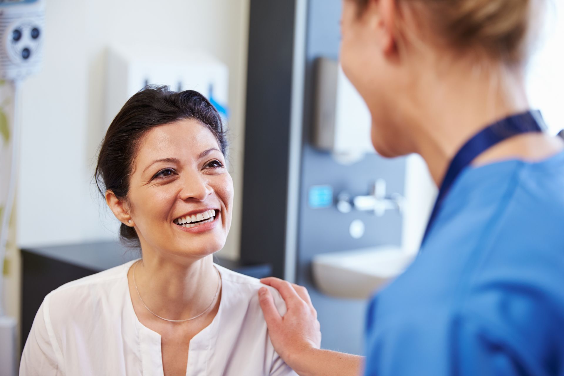 A photo of a dental patient smiling at her dentist.
