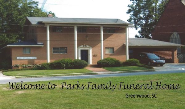 Parks Family Funeral Home brick building with columns and text reading “Welcome to Parks Family Funeral Home, Greenwood, SC”