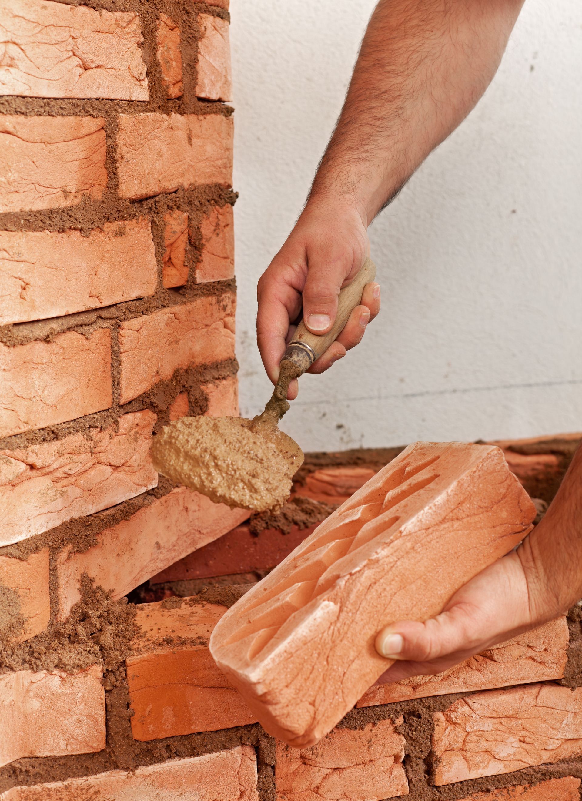 brick chimney masonry repair worker on ladder on roof