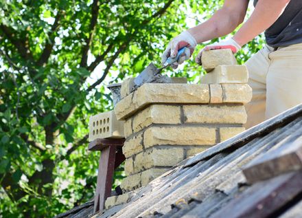 Mason in the process of a Brick Chimney Repair in Worcester, MA