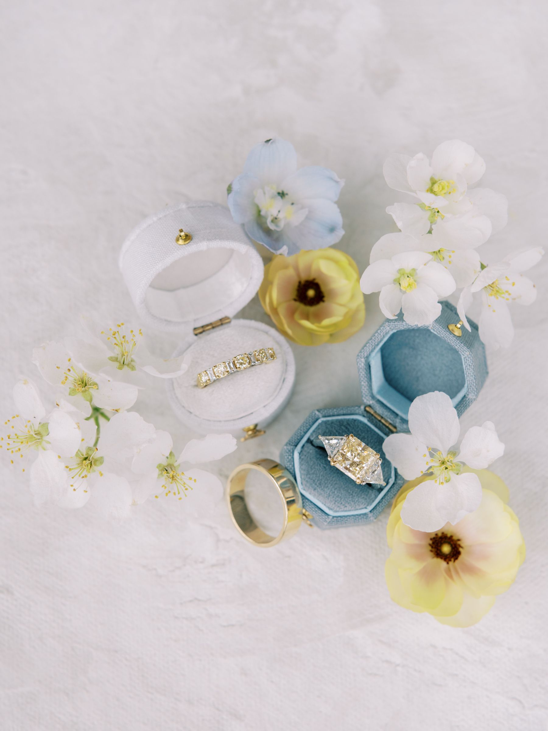 Wedding rings in velvet ring boxes with flowers.