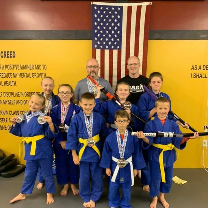 a group of kids are posing for a picture in front of an american flag