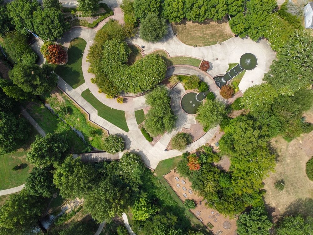 An aerial view of a park filled with lots of trees and grass.