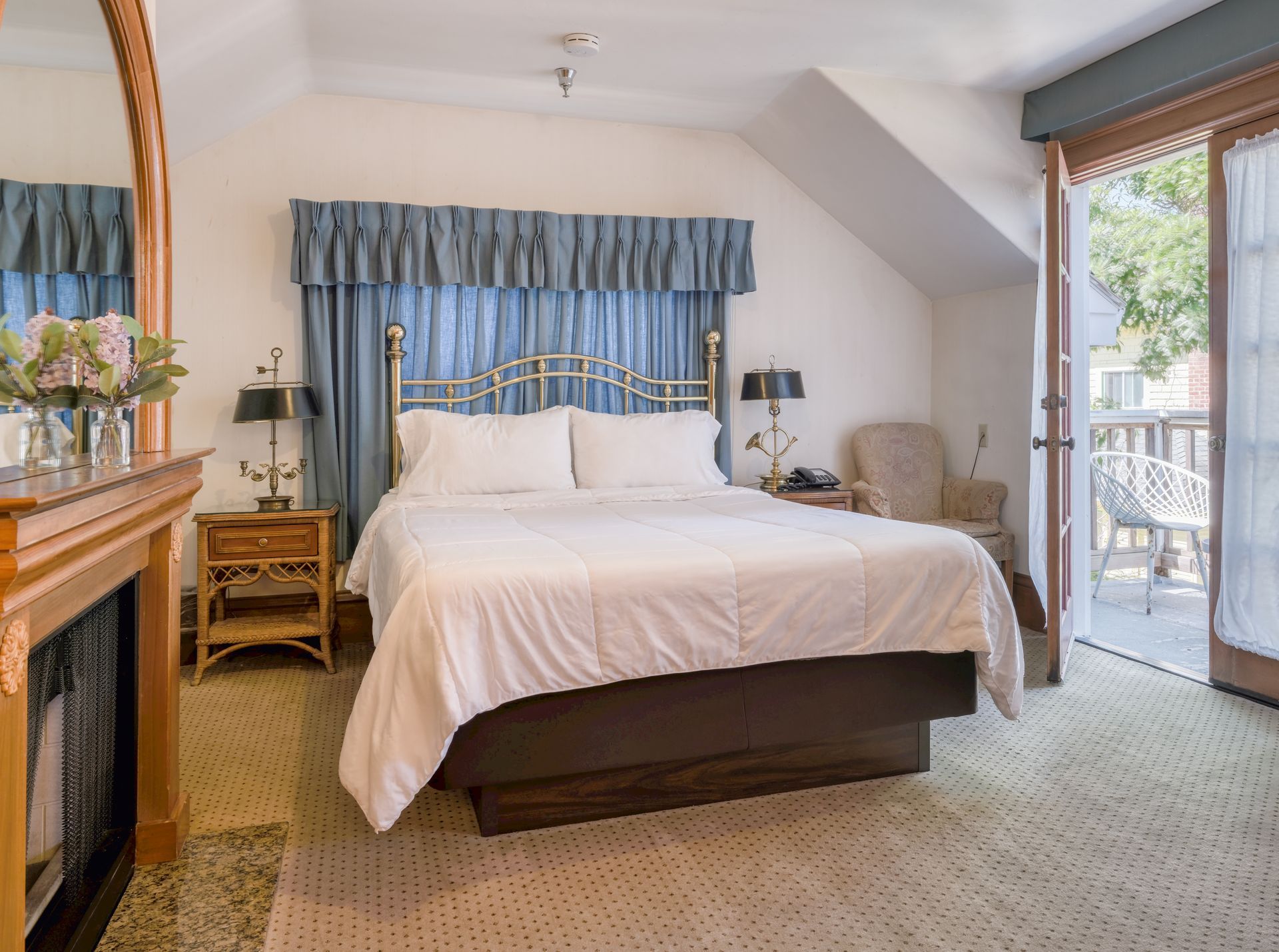 Bedroom with a large bed, blue valance, and sliding glass door to a balcony.